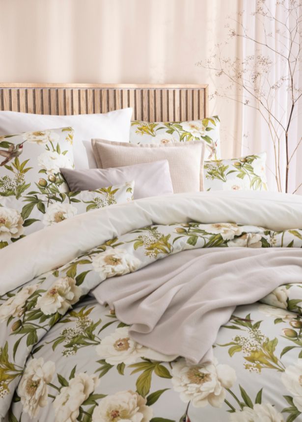 Florale Bettwäsche Yvonne in Beige mit weißen Blüten und grünen Blättern, kombiniert mit unifarbener Bettwäsche Valetta, Wohndecke Trevi und mehreren Dekokissen auf Doppelbett in hellem Schlafzimmer